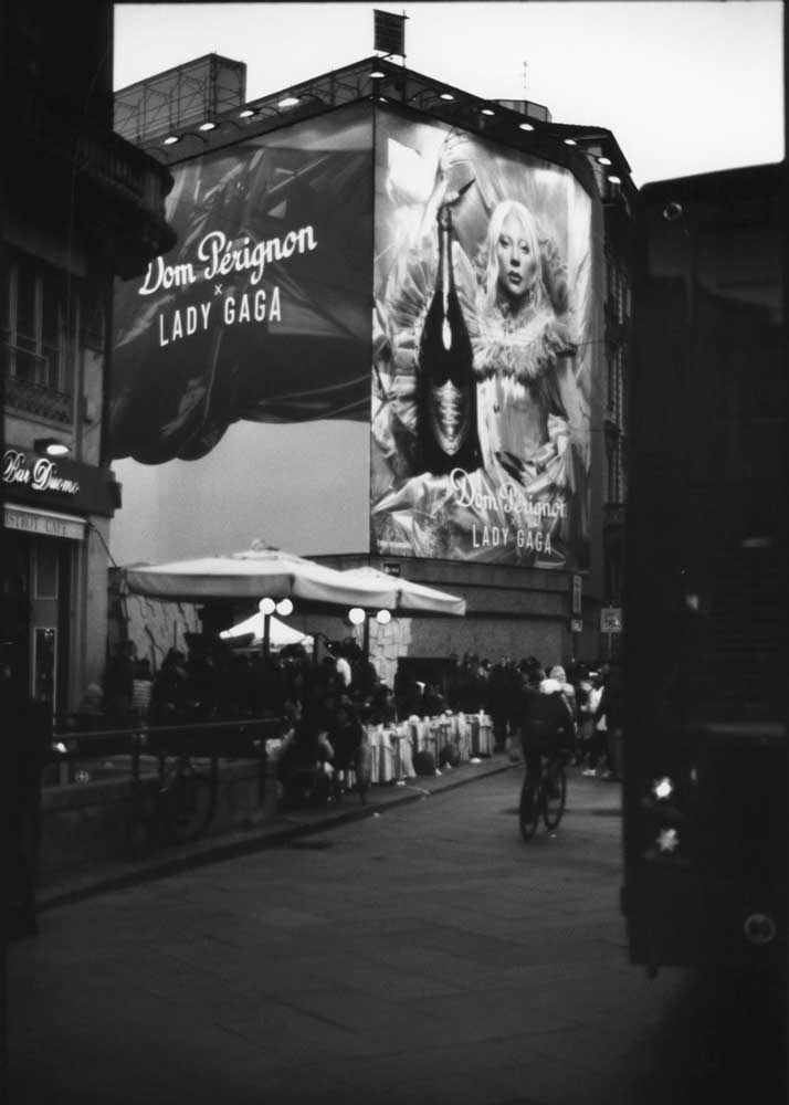 Happy hour a Milano sotto una grande insegna pubblicitaria di Dom Perignon